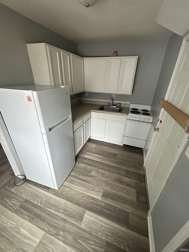 kitchen featuring dark hardwood / wood-style flooring, sink, white appliances, and white cabinets