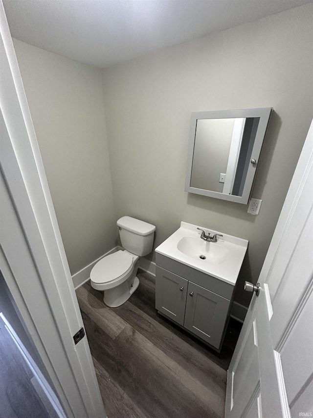 bathroom featuring wood-type flooring, vanity, and toilet