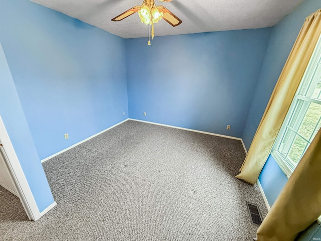 unfurnished room with a textured ceiling, ceiling fan, and carpet