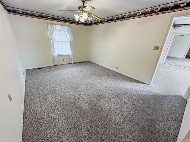 spare room featuring ceiling fan and carpet