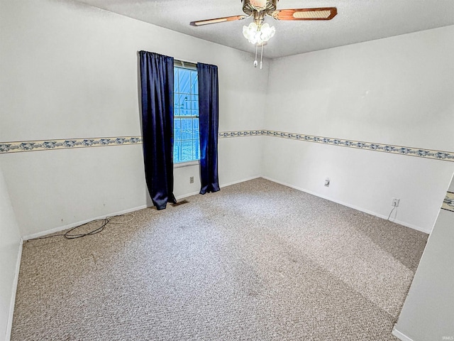 empty room featuring ceiling fan, carpet floors, and a textured ceiling