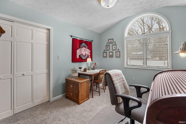 home office with vaulted ceiling, light carpet, and a textured ceiling