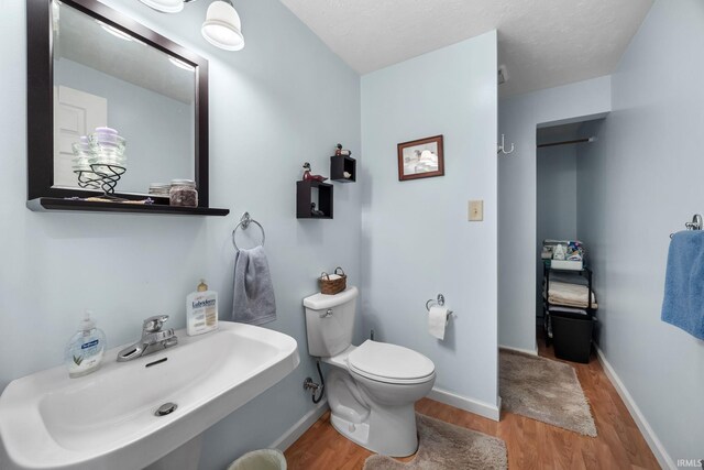 bathroom featuring hardwood / wood-style flooring, toilet, and sink