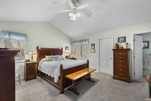 carpeted bedroom with ceiling fan, vaulted ceiling, and a textured ceiling