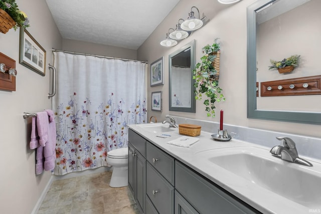 bathroom with vanity, curtained shower, a textured ceiling, and toilet