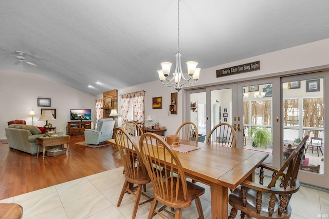 dining space featuring lofted ceiling, a textured ceiling, french doors, and a healthy amount of sunlight