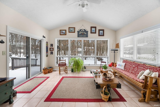 living room with lofted ceiling, light tile patterned floors, a textured ceiling, and ceiling fan