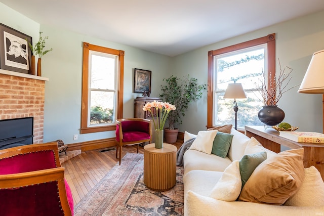 living area featuring a brick fireplace and hardwood / wood-style floors