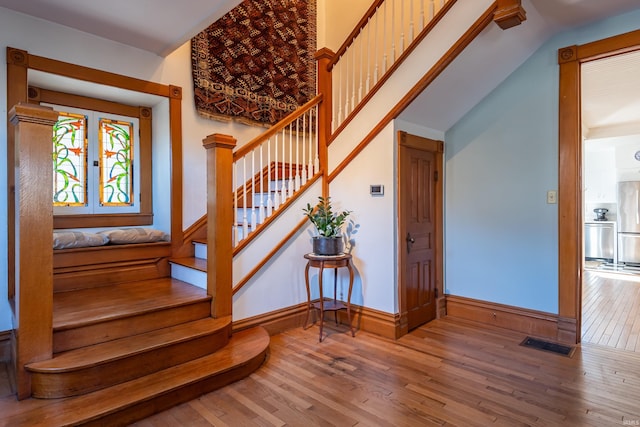 staircase with hardwood / wood-style flooring