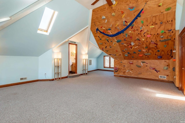 bonus room featuring carpet floors, lofted ceiling with skylight, and ceiling fan