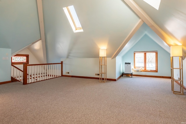 additional living space with lofted ceiling with skylight and carpet