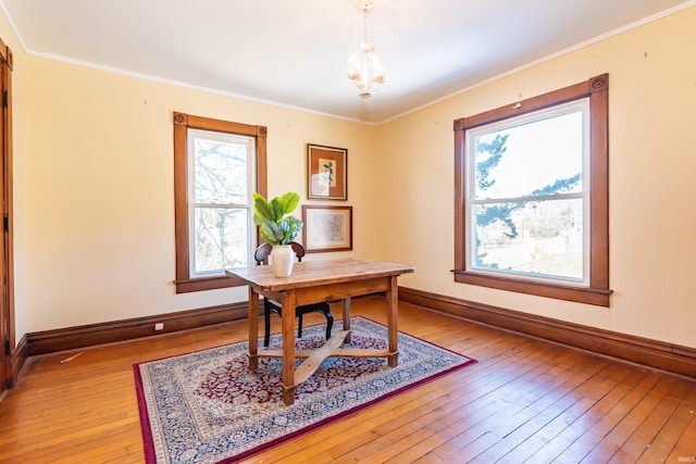 home office featuring crown molding, an inviting chandelier, and light hardwood / wood-style flooring