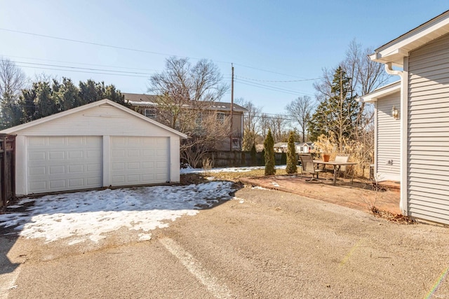 snow covered garage featuring a detached garage