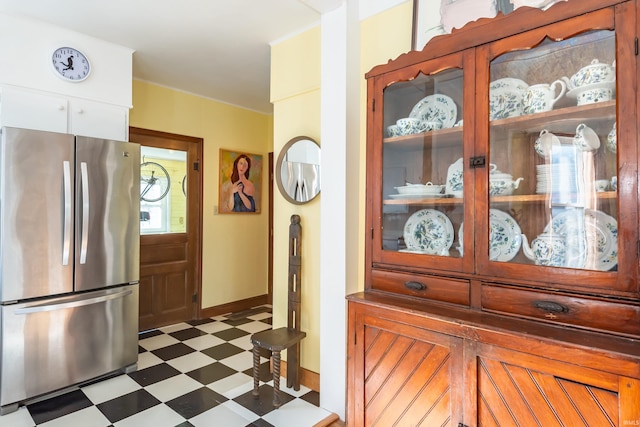 kitchen featuring stainless steel refrigerator and white cabinets