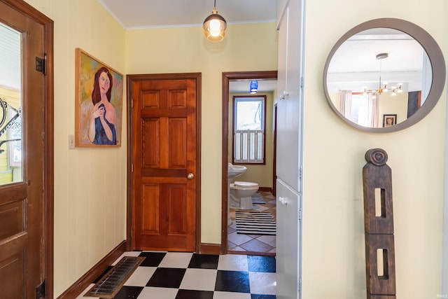 foyer with ornamental molding and a chandelier