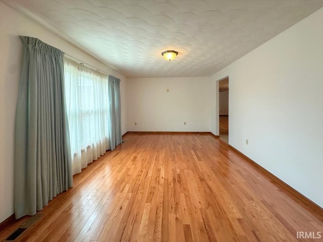 empty room featuring a textured ceiling and light wood-type flooring