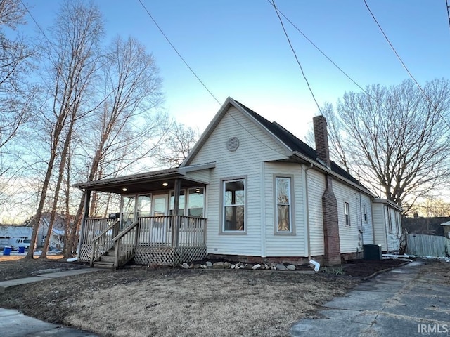 bungalow with a porch and central air condition unit