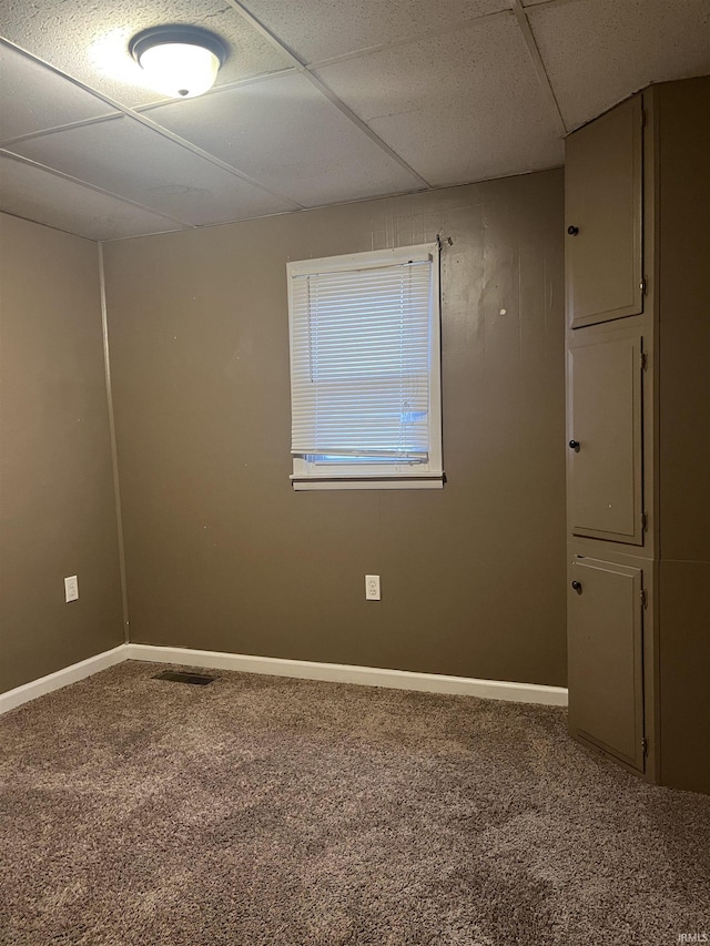 carpeted spare room with a paneled ceiling