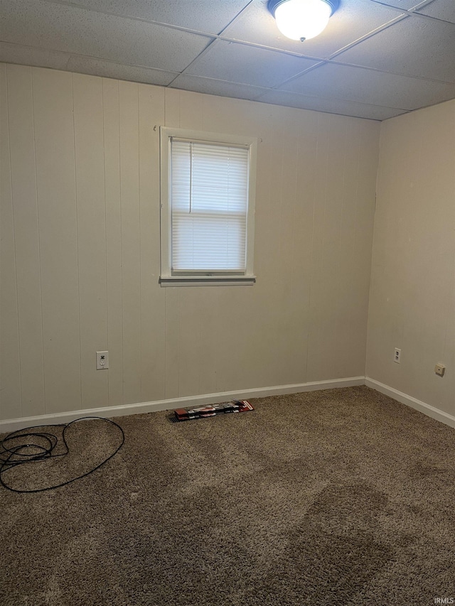 spare room featuring a paneled ceiling and carpet