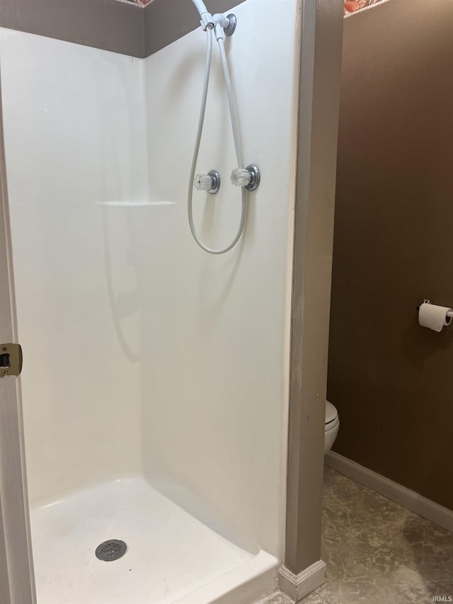 bathroom with toilet and a shower