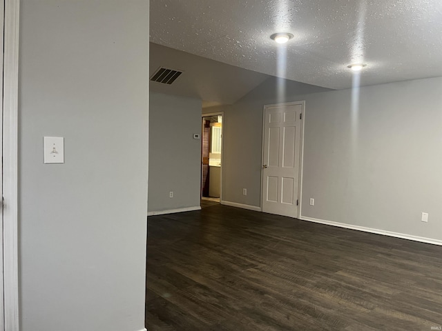 unfurnished room featuring dark hardwood / wood-style floors and a textured ceiling