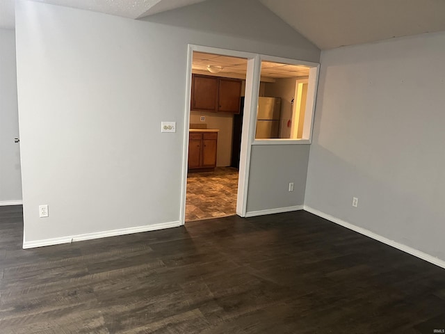 unfurnished room featuring dark hardwood / wood-style flooring and lofted ceiling