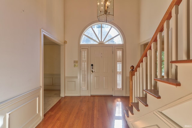 foyer entrance with a chandelier, hardwood / wood-style floors, and a high ceiling