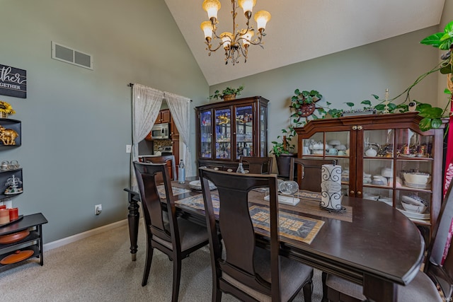 dining area featuring an inviting chandelier, carpet floors, and high vaulted ceiling