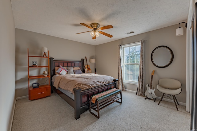 carpeted bedroom with ceiling fan and a textured ceiling