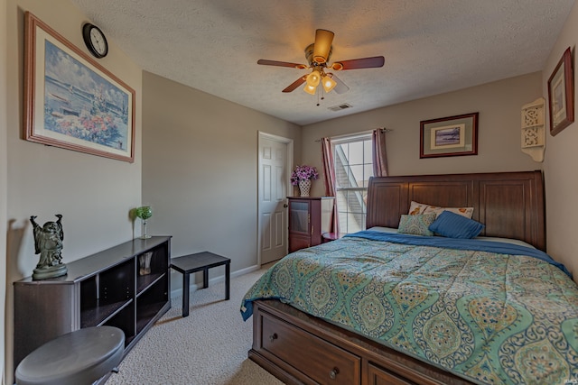 carpeted bedroom featuring ceiling fan and a textured ceiling