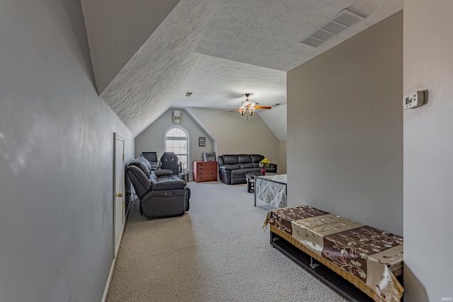 carpeted bedroom with ceiling fan, vaulted ceiling, and a textured ceiling