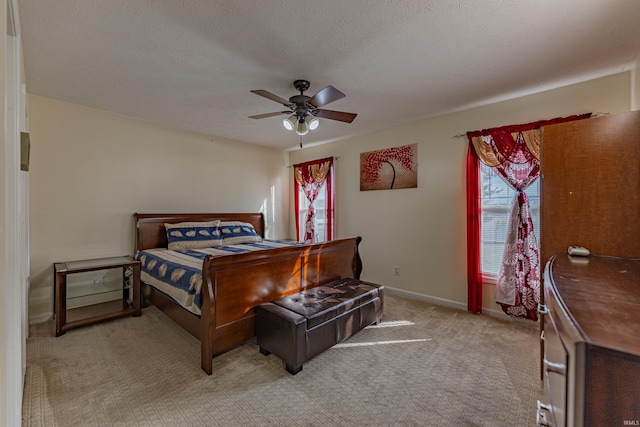 bedroom featuring ceiling fan, light carpet, and a textured ceiling