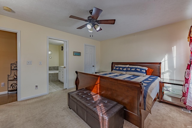 bedroom with connected bathroom, light colored carpet, a textured ceiling, and ceiling fan