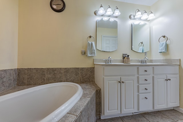 bathroom with vanity, tile patterned floors, and tiled bath