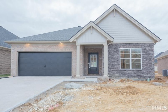 view of front of property with a garage and central air condition unit