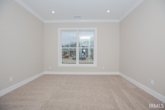 carpeted spare room featuring crown molding