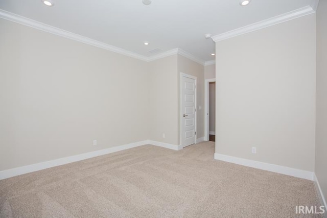 carpeted spare room featuring crown molding