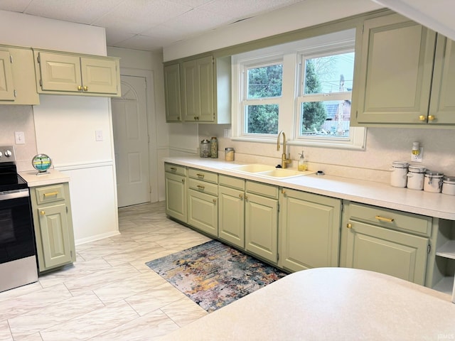 kitchen with electric stove, a paneled ceiling, sink, and green cabinetry