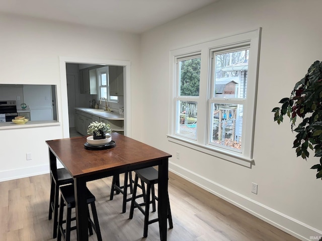 dining room featuring sink and light hardwood / wood-style flooring