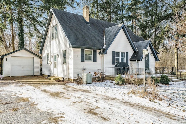 view of front of house featuring an outbuilding, central AC unit, a garage, and a deck