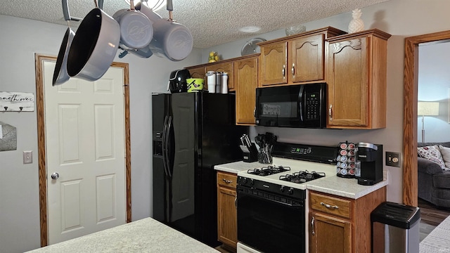 kitchen featuring a textured ceiling and black appliances