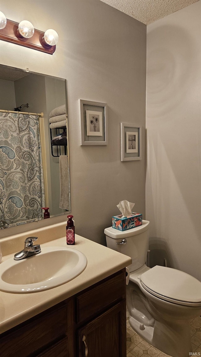 bathroom with vanity, a textured ceiling, and toilet