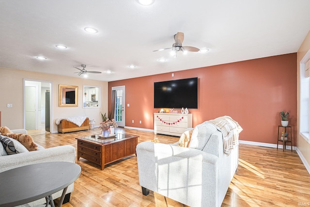 living room featuring ceiling fan and light wood-type flooring