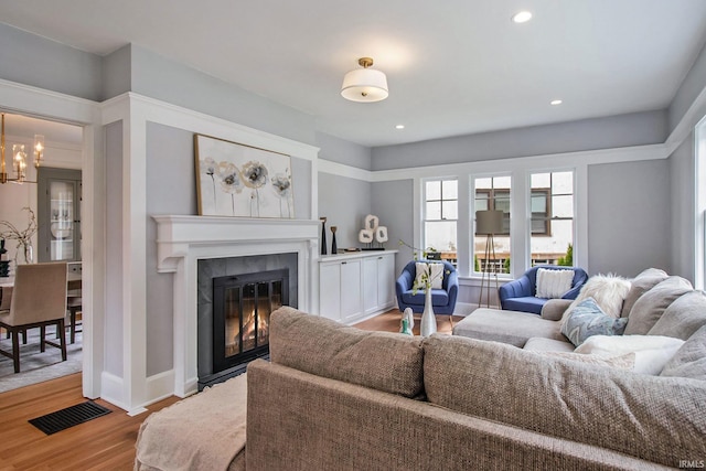 living room featuring a notable chandelier and light wood-type flooring