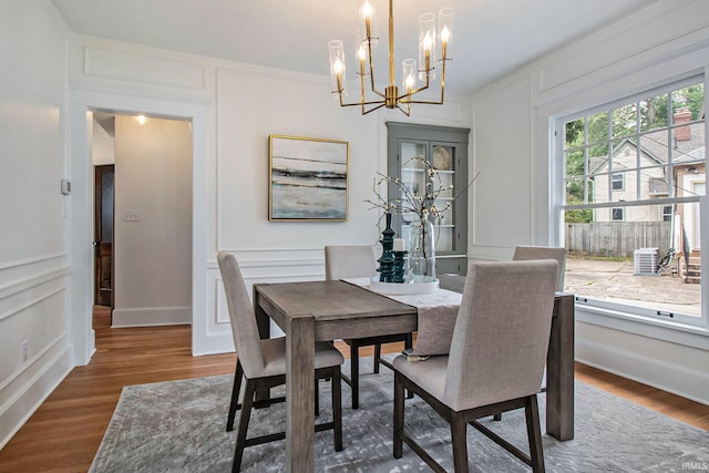 dining room with dark wood-type flooring and a notable chandelier