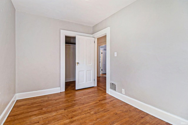 unfurnished bedroom featuring wood-type flooring and a closet