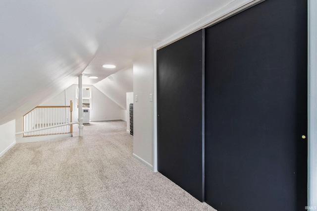 bonus room with vaulted ceiling and carpet flooring