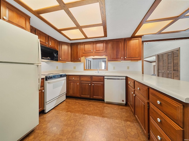 kitchen with sink, white appliances, and kitchen peninsula