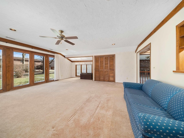 unfurnished living room with ceiling fan, carpet floors, and a textured ceiling