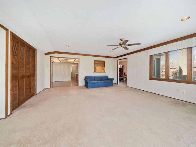 interior space featuring connected bathroom, crown molding, a textured ceiling, ceiling fan, and carpet